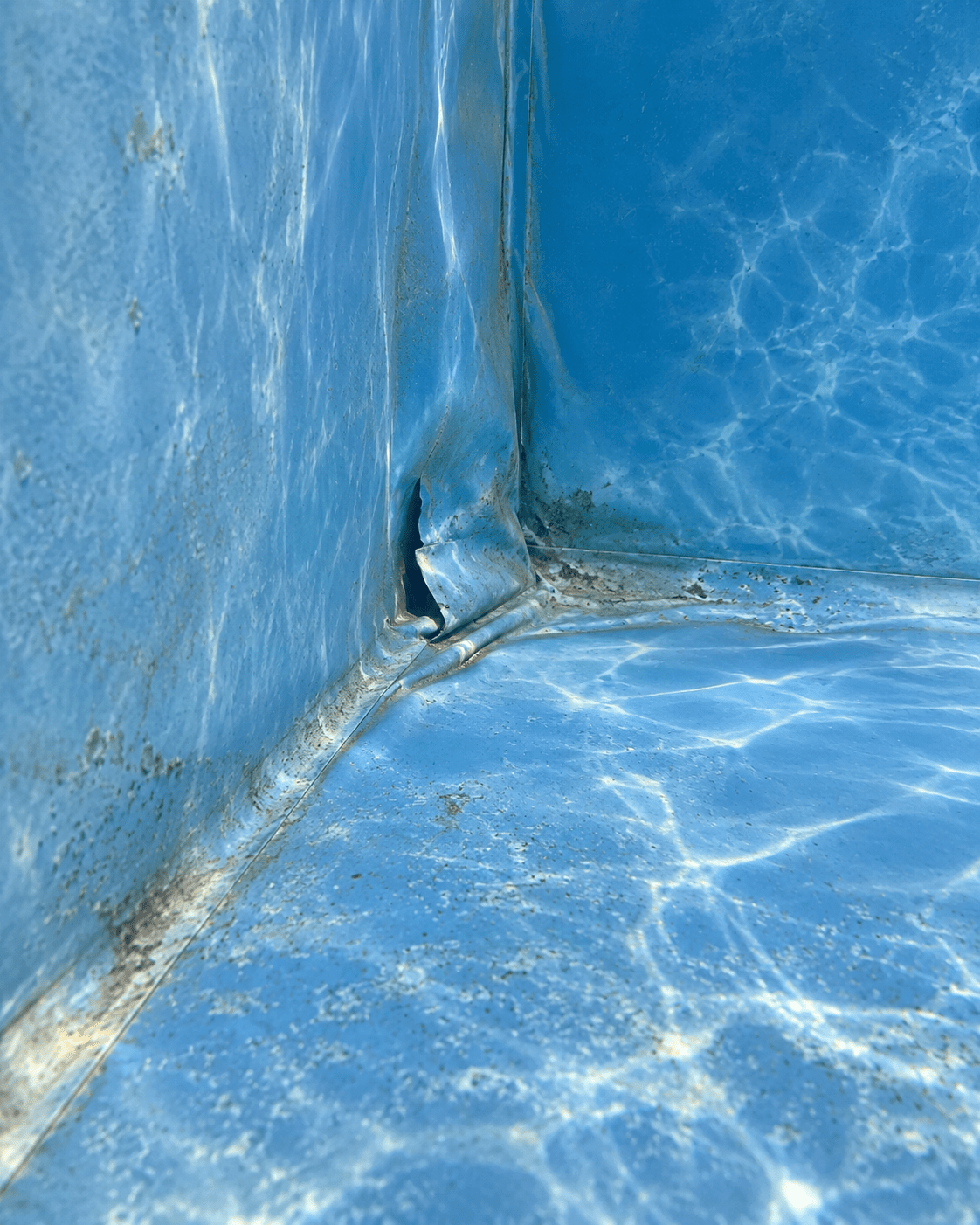 Déchirure dans un liner de piscine bleu