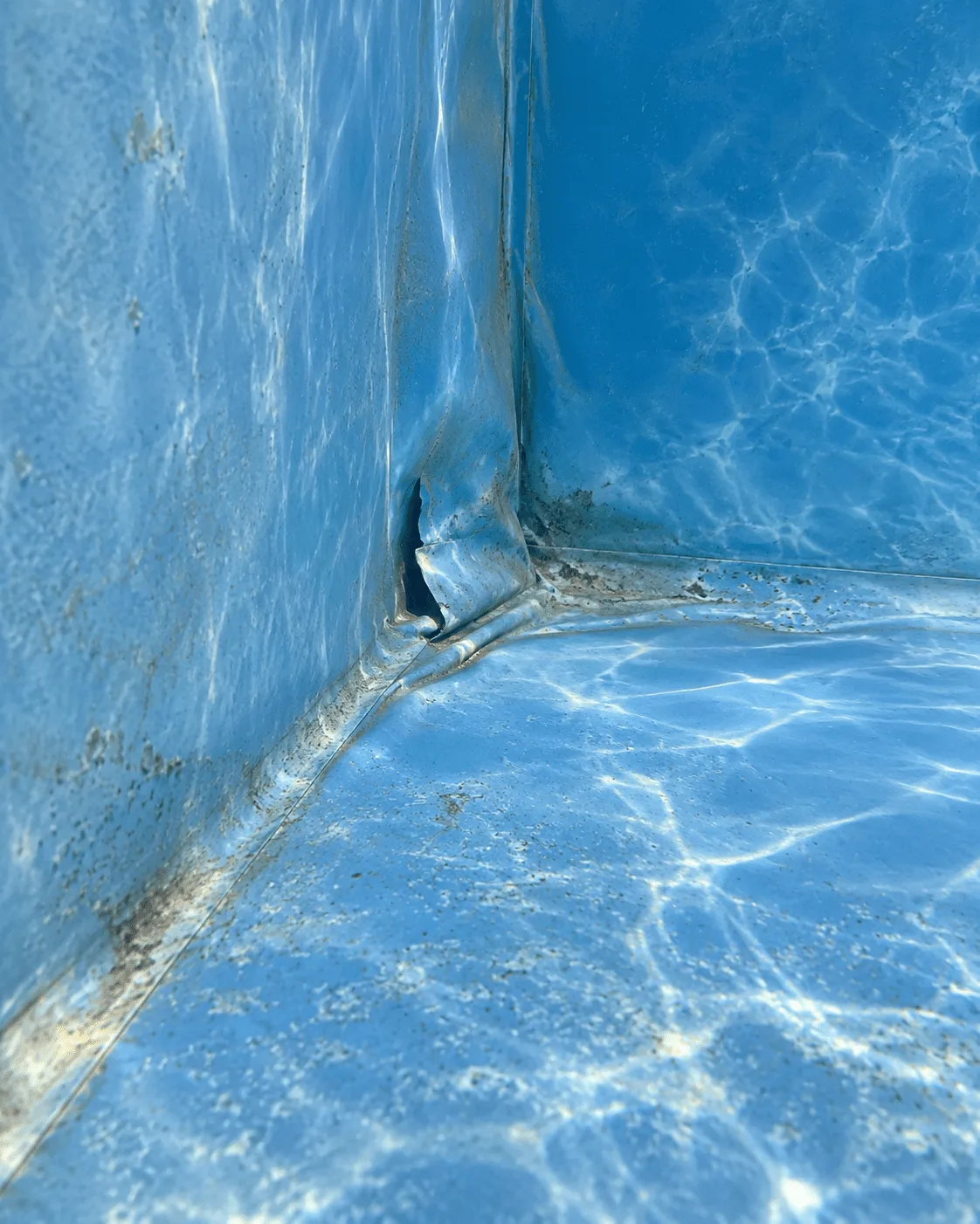 Déchirure dans un liner de piscine bleu