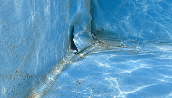 Déchirure dans un liner de piscine bleu